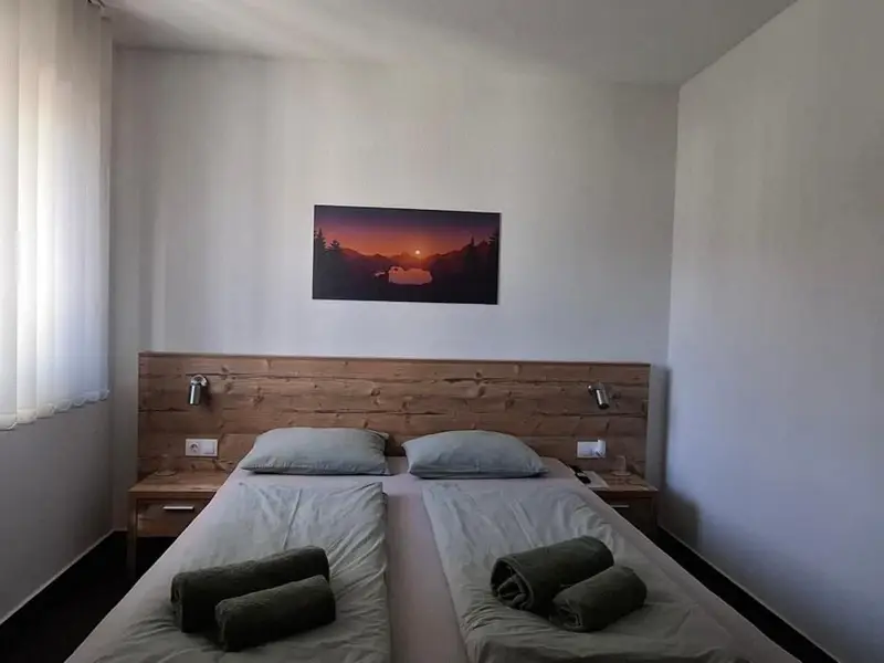 Bračni krevet s drvenim uzglavljem i složenim peškirima