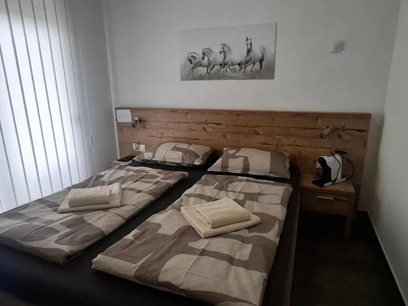 Soba s dva kreveta i slikom konja iznad uzglavlja