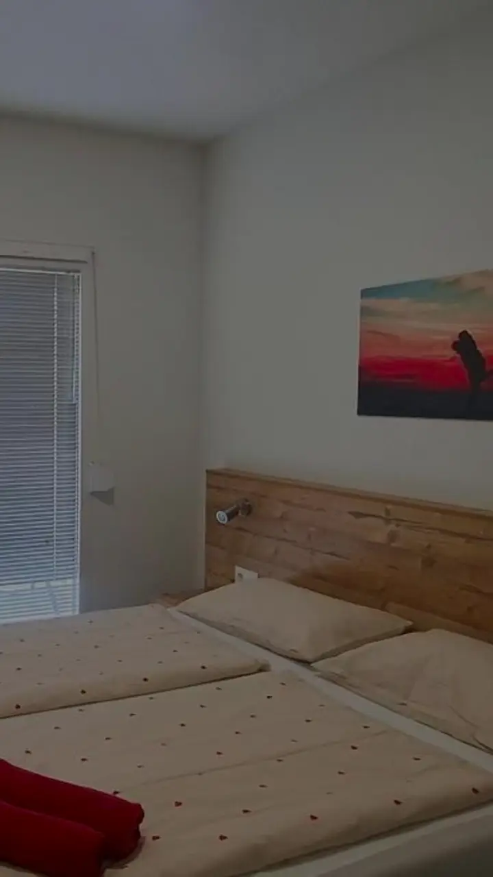 Svijetla spavaća soba s bračnim krevetom i klima-uređajem